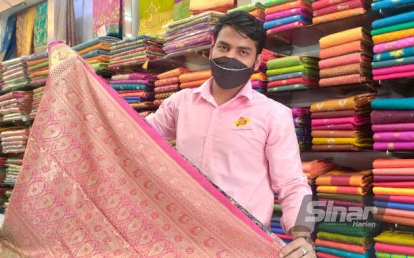 Mohd Indran Khan menunjukkan antara kain sari terbaru Kanchipuram yang mendapat permintaan pelanggan untuk perayaan kali ini.