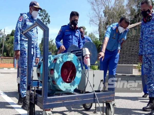 Che Adam (dua, kanan) menunjukkan cara penggunaan siren PWS pada sesi uji lari di pekarangan padang kawat pejabat APM Pahang pada Selasa.