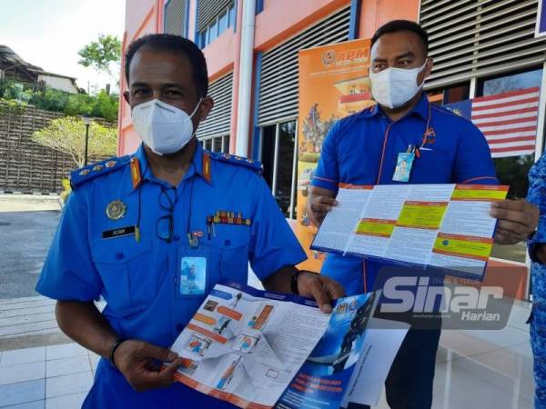 Che Adam menunjukkan risalah mengenai siren PWS yang akan diedarkan kepada masyarakat.