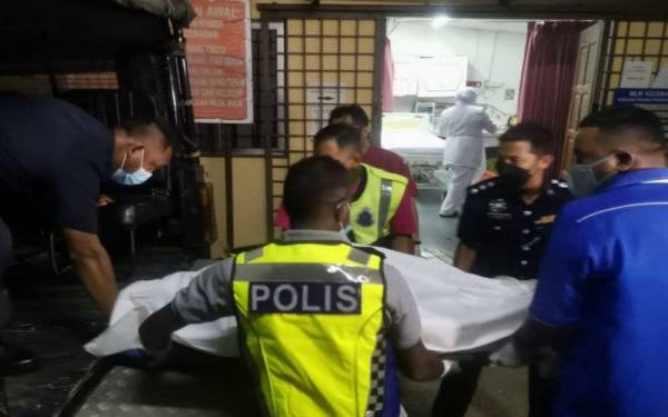 Anggota polis membantu mengangkat mayat mangsa untuk dibawa ke Unit Forensik HTAA dari Klinik Kesihatan Bukit Goh.