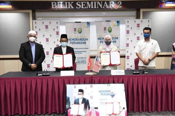 Nik Maheran (dua,kanan) menunjukkan MoU yang ditandatangani bersama pihak KIAS.