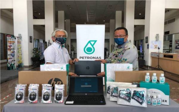 Sazli (kiri) menyampaikan sumbangan komputer riba dan barangan keperluan kepada Dr Rusdi untuk kegunaan Pusat Penilaian Covid-19 (CAC) dan Jabatan Kesihatan Melaka pada 21 Oktober lalu.