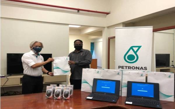 Sazli (kiri) menyampaikan sumbangan komputer riba dan barangan keperluan kepada Veerapan untuk kegunaan Jabatan Kesihatan Negeri Sembilan pada 22 Oktober lalu.