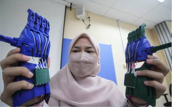 Pelajar Sarjana Bioperubatan dan Sains Kesihatan Universiti Teknologi Malaysia (UTM), Nur Amalina Ras menunjukkan replika tangan robotik yang sudah siap 100 peratus ketika Majlis Serahan Tangan 3D ke Yaman 2021 pada Rabu. - Foto Bernama