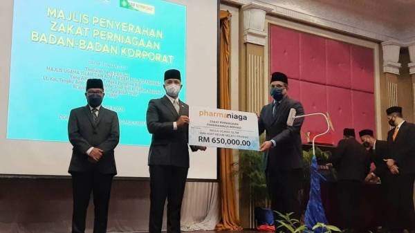 Tengku Amir Nasser (dua, kiri) menerima sumbangan zakat perniagaan daripada Pharmaniaga pada di Hotel GrandMakmur pada Khamis.