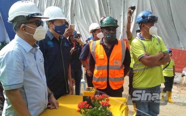 Hasan (kiri) bersiap sedia bagi melakukan gimik sewaktu Majlis Pecah Tanah Terowong Koridor Utara LRA Langat 2, pada Jumaat.
