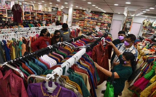 Kelihatan penganut Hindu membeli sari baharu di sebuah kedai pakaian di Lebuh Pasar. - Foto fail Bernama