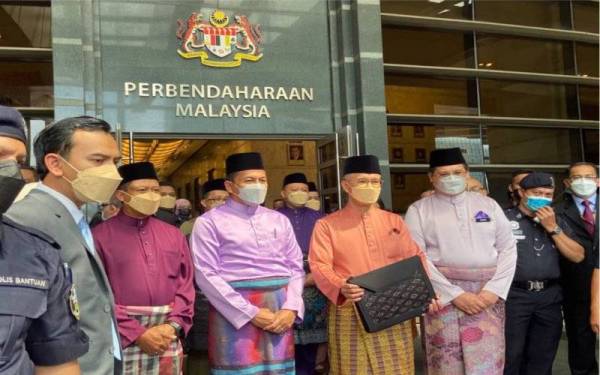 Tengku Zafrul memegang beg yang mengandungi teks ucapan Bajet 2022.