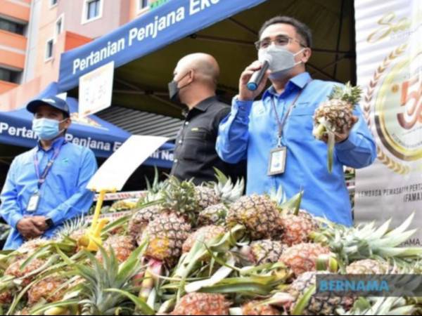 Abdul Rashid Bahri (kanan) mempromosikan nanas tempatan semasa program jualan My Best Buy FAMA. - Foto Bernama 