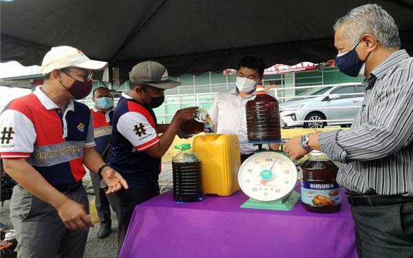 Mohd Zahir (kiri), Ken Hwa (dua kanan) dan Mohd Zamri (kanan) ketika Pelancaran Kempen Kitar Semula Minyak Masak Terpakai di Lukut, Port Dickson, pada Jumaat.