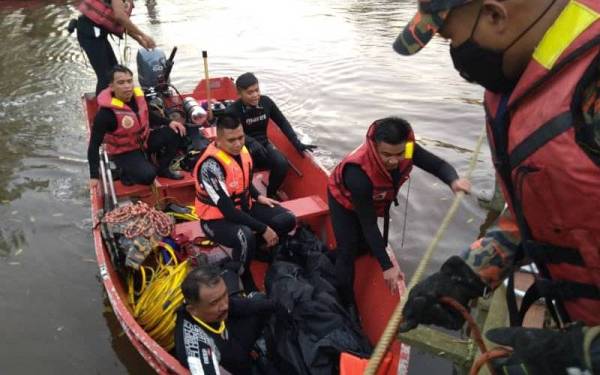 Anggota bomba mengusung mayat mangsa ke jeti selepas ditemukan petang Sabtu.