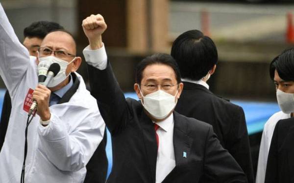 Fumio Kishida (tengah) mengangkat tangan semasa kempen partinya. Foto AFP