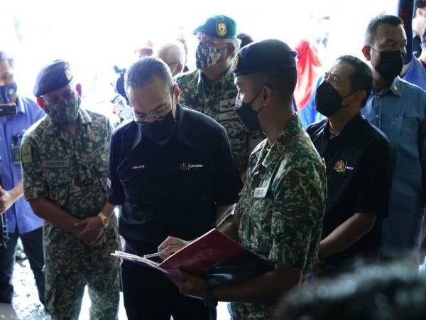 Hishammuddin (tengah) diberi penerangan tentang Projek Jiwa Murni Kementerian Pertahanan ketika lawatannya.