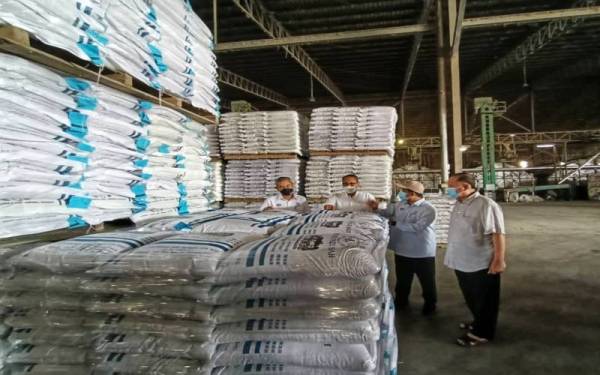 Ahmad Tarmizi (dua,kanan) meninjau bekalan benih padi di Kilang Seri Merbok, Simpang Empat di sini pada Ahad.