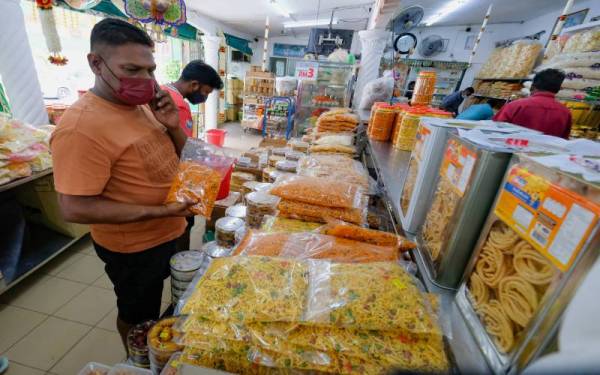Pengunjung mengambil peluang untuk membeli pelbagai jenis kekacang dan kerepek ketika tinjauan Bernama di Kampung Kacang Puteh, Buntong sempena persiapan menyambut Deepavali pada Khamis depan. - Foto Bernama