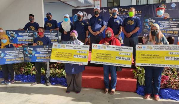 Syed Abu (empat dari kiri) dan Menteri Pembangunan Usahawan dan Koperasi, Tan Sri Noh Omar (tiga dari kanan) bergambar bersama penerima bantuan LKIM pada Majlis Sambutan Road To Jubli Emas 50 Tahun LKIM dan Mafi Prihatin Nelayan Peringkat LKIM Negeri Selangor di sini pada Ahad.