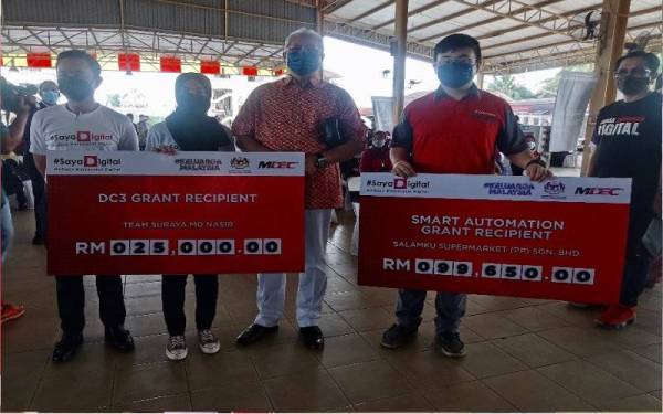 Annuar (tengah) bersama dua wakil penerima geran MDEC di Kompleks Yayasan Kemiskinan Kelantan, Kota Bharu pada Ahad.