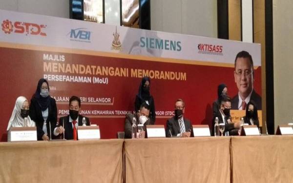 Amirudin (tiga dari kiri) menurunkan tandatangan sewaktu MoU antara kerajaan Selangor, STDC dan Siemens di Hotel Le Meridean, pada Isnin.
