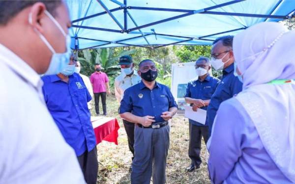 Saarani mendengar penerangan ketika mengadakan lawatan ke beberapa tapak projek di sekitar Padang Rengas.