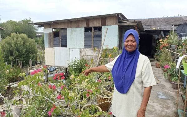 Salbiah menunjukkan rumahnya yang dibina di atas air di Kampung Benteng Kukup.