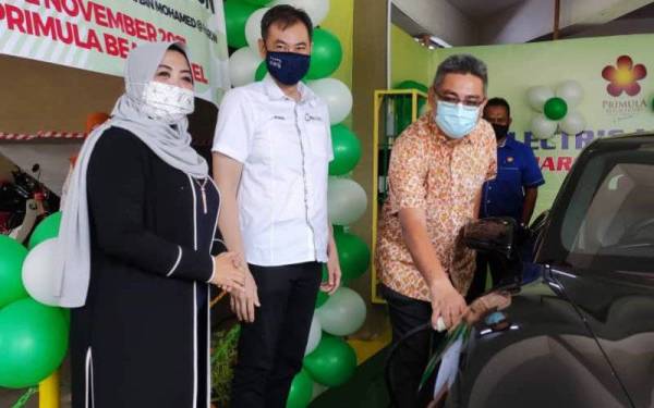 Shahrol (dua dari kiri) melihat Burhanuddin mengecas kenderaan elektrik di stesen pengecasan di Primula Beach Hotel di sini pada Selasa.