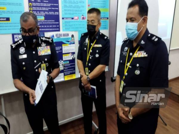 Ramli (kiri) menunjukkan risalah 'trend' terkini jenayah komersial yang akan diedarkan kepada umum bagi meningkatkan kesedaran masyarakat terhadap kes-kes penipuan yang terus meningkat.