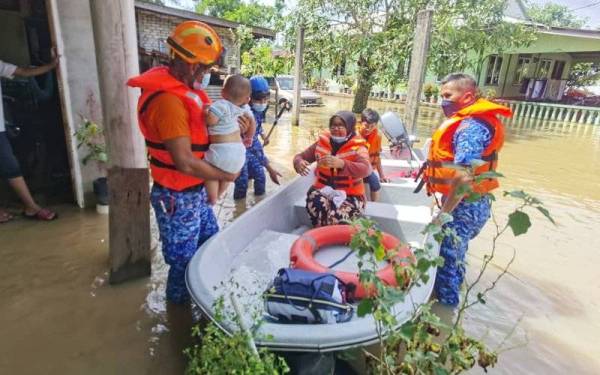 Anggota APM Kota Setar menjalankan operasi memindahkan mangsa banjir di Kampung Kuar Mukim Tajar ke PPS SK Darul Hikmah pada Selasa. - Foto APM Kedah