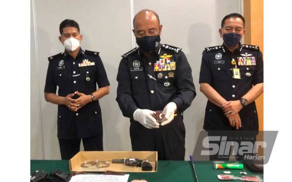 Shafien (tengah) menunjukkan 28 peluru hidup yang dirampas dalam serbuan itu. - FOTO SINAR HARIAN