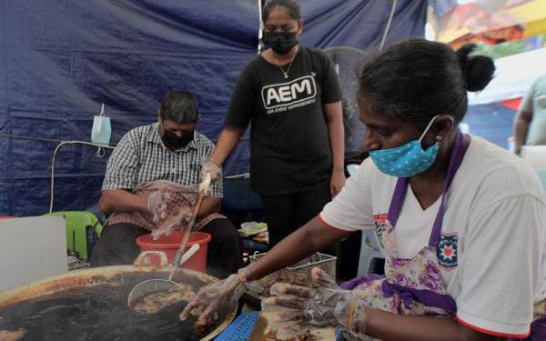 M Mageswary 56, (kanan) dan saudaranya Raja Ramasamy, 46, (kiri) menghabiskan 100 kilogram tepung yang telah siap diadun sehari dalam menghasilkan kuih Adhiresam bagi memenuhi permintaan masyarakat India menjelang sambutan Hari Deepavali esok ketika tinjauan Bernama di Bazar Deepavali, Little India pada Rabu. - Foto Bernama