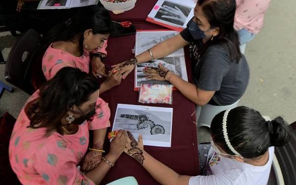 Dua peniaga wanita memberi perkhidmatan menginai pelanggannya menjelang sambutan Deepavali esok ketika tinjauan Bernama di Bazar Deepavali, Little India hari ini.