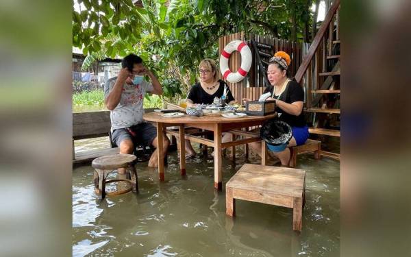 Pelanggan menyukai suasana dan percikan air, sambil menikmati barbeku yang dibakar di atas meja yang terendam di dalam air. - Foto Bernama