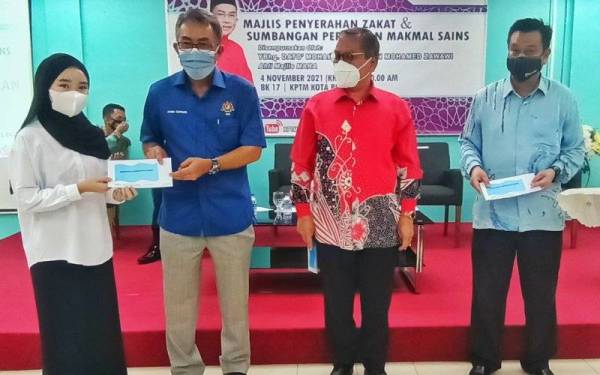 Mohamed Farid (dua dari kiri) menyampaikan zakat Zakat kepada pelajar di KPTM Kota Bharu pada Khamis.