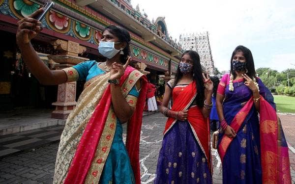 Darisyhini Raman 19, (kiri) bersama sepupunya Shalini Ellappant 34, (kanan) dan Thivya Periyasami 16, berswafoto selepas mnghadiri upacara keagamaan dengan mengamalkan SOP di Kuil Kallumalai Arulmigu Subramaniar di Gunung Cheroh, Ipoh. - Foto Bernama