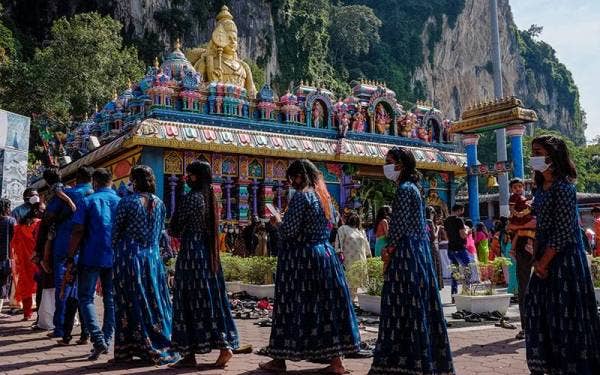 Penganut Hindu mematuhi SOP dengan memakai pelitup muka dan mengamalkan penjarakan fizikal ketika beratur menunggu giliran untuk masuk ke dalam Kuil Sri Maha Mariamman Dhevasathanam, Batu Caves pada Khamis. - Foto Bernama