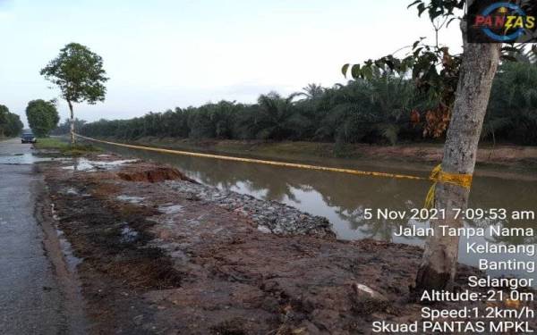 Tebing longkang besar di jalan utama berhadapan Pantai Kelanang runtuh akibat limpahan air pasang yang deras pada pagi Jumaat. - Foto Skuad Pantas MPKL