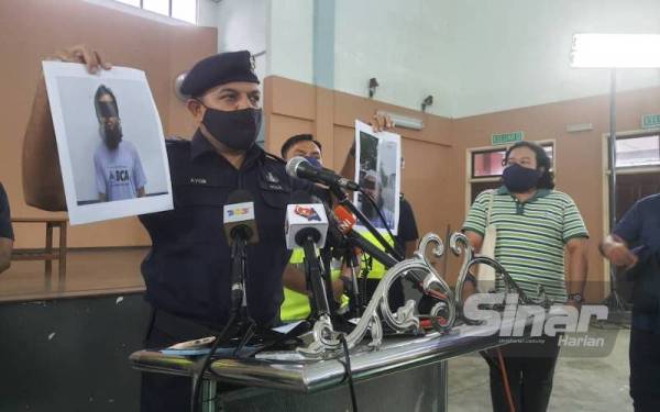 Ayob Khan menunjukkan gambar lelaki warga Bangladesh yang ditahan kerana mengeluarkan kenyataan khianat pada sidang akhbar di PPR Larkin, Johor Bahru pada Sabtu.