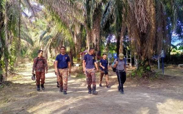 Pasukan bomba bersama salah seorang mangsa yang melakukan aktiviti pendakian di Bukit Broga pada Sabtu.