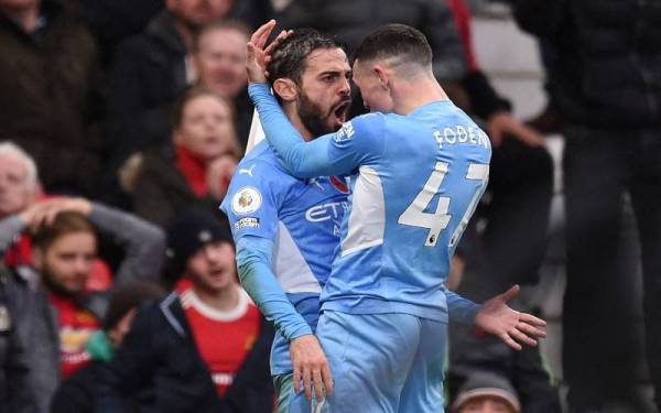 Silva (kiri) meraikan jaringan kedua bersama Phil Foden semasa perlawanan Manchester United menentang Manchester City di Old Trafford, Manchester, malam ini. - Foto AFP