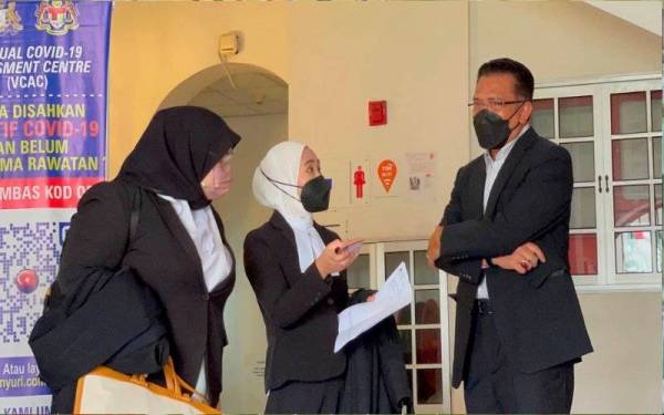 Abdul Latif (kanan) berbincang dengan barisan peguamnya sebelum bermula prosiding bagi pertuduhan kes rasuah di Mahkamah Tinggi Johor Bahru, Johor Bahru pada Ahad.