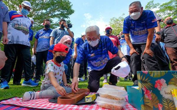 Perdana Menteri Datuk Seri Ismail Sabri Yaakob mencuba permainan congkak bersama seorang kanak-kanak selepas melancarkan sambutan Bulan Keluarga Malaysia (BKM) di Taman Botani Perdana hari ini.