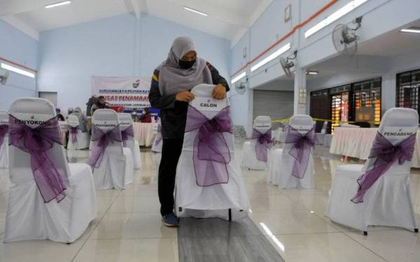 Petugas SPR, Nurul Farah Illyani Zulastry membuat persiapan sebelum berlangsungnya proses penamaan calon bagi PRN Melaka di Dewan Kasturi Japerun pada Ahad. - Foto Bernama