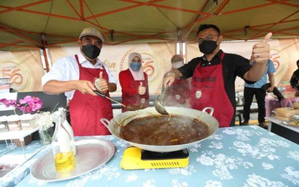 Abd Rahim (kiri) dan Saiful menyediakan masakan opor Pahang UTC Kuantan pada Ahad.