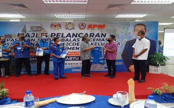 Latiff (tiga dari kanan) menyampaikan jaket CDERT kepada penghulu Mukim Mersing sebagai gimik perasmian Majlis Pelancaran CDERT Keluarga Malaysia Parlimen Mersing di Politeknik Mersing pada Sabtu.