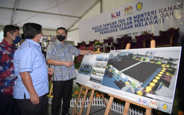 Mohamed Azmin melihat pelan binaan baik pulih medan selera pada Majlis Jamuan Teh bersama Persatuan Peniaga dan Penduduk Taman Melawati di Medan Selera Taman Melawati pada Ahad. - Foto Bernama