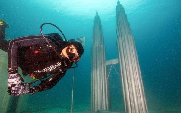 Penyelam bergambar berlatarkan monumen Menara Berkembar Petronas Kuala Lumpur pada perasmian 1st ASEAN Underwater Mini Landmark (AUMiL) di Pulau Bidong yang disempurnakan oleh Menteri Pelancongan, Seni dan Budaya Datuk Seri Nancy Shukri.