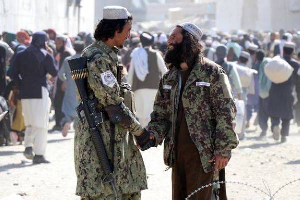 Taliban stand guard as people move forward to cross into Pakistan at Pakistan-Afghanistan border in Spin Boldak, Afghanistan, Nov 3, 2021. Photo from EPA