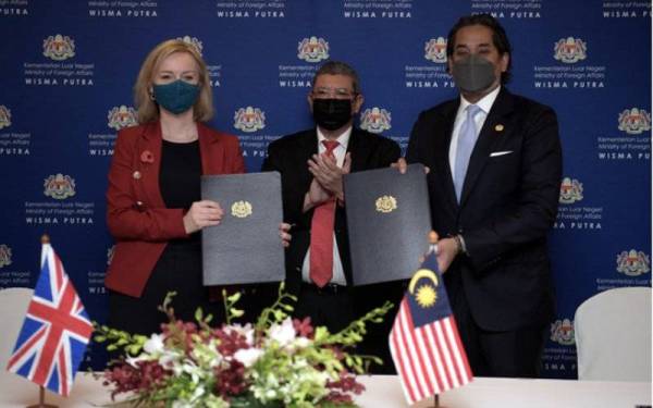 Saifuddin (tengah) menyaksikan pertukaran Memorandum Persefahaman (MoU) antara Khairy Jamaluddin (kanan) dengan Elizabeth Truss (kiri) pada Isnin. - Foto Bernama