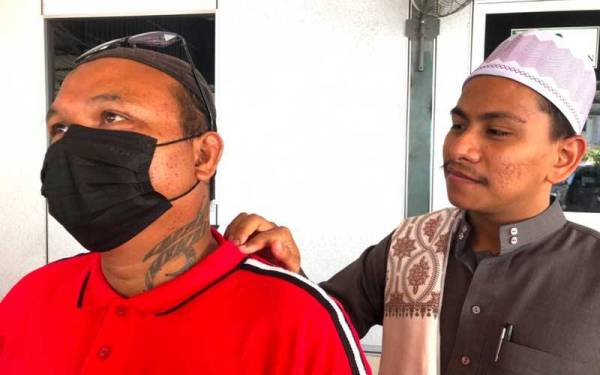 Tian Chuan (kiri) menunjukkan tatu yang dicacah di bahagian kiri lehernya kepada Pengasas BeDaie, Muhammad Amar Mirza Abd Kadir Jailani.