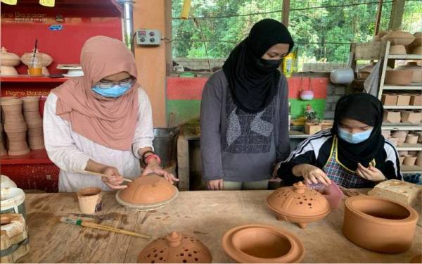 Syazwani (tengah) sentiasa memantau kerja-kerja mereka corak hiasan yang dilakukan pekerjanya.