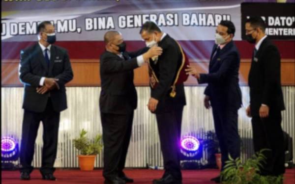 Saarani (dua dari kiri) menyempurnakan penganugerahan Tokoh Guru Negeri Perak 2021 kepada Abdul Hashim pada sambutan Hari Guru Negeri Perak Tahun 2021 di Dewan Jubli Perak, Kuala Kangsar pada Selasa.